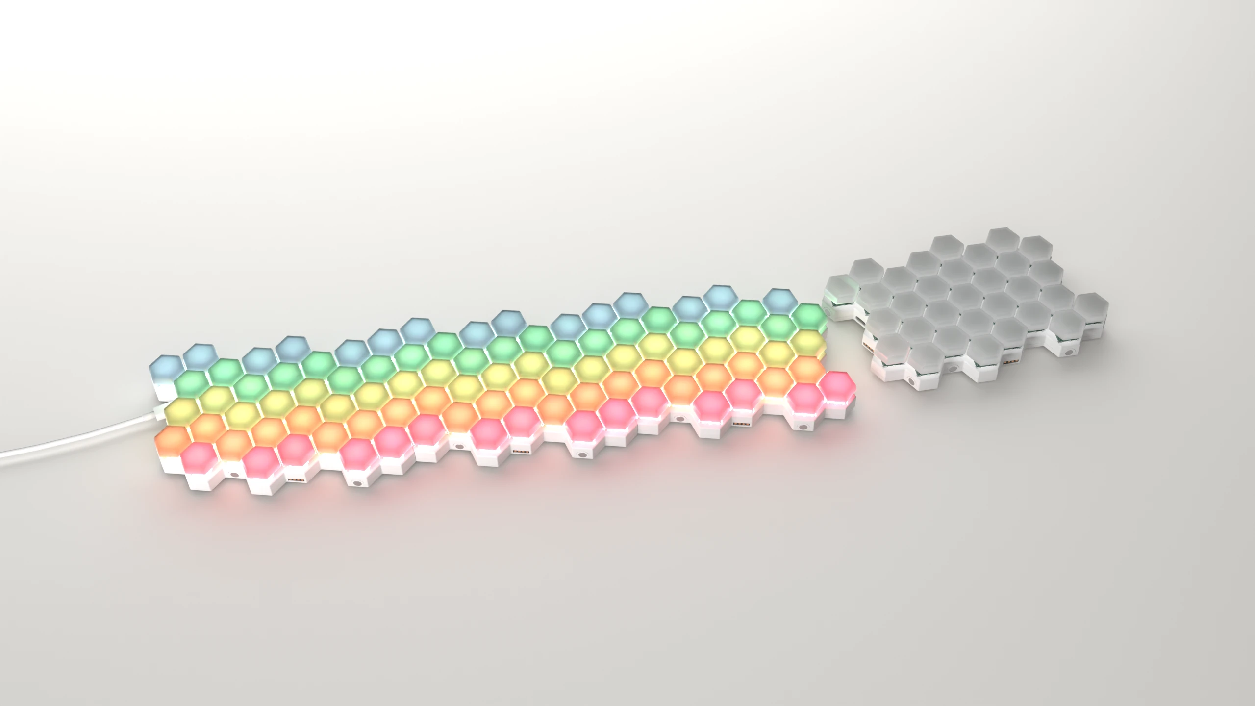 Four Miso keyboards side by side: three of them connected together, lit in a rainbow gradient, and a single unconnected unit.
